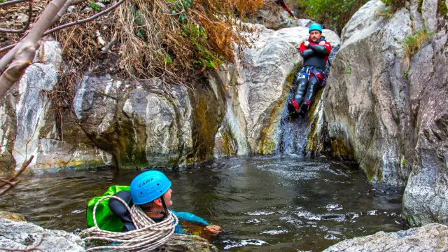 Personne glissant le long d’un toboggan naturel en canyoning à Thuès-les-Bains.