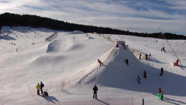 Familles et enfants profitant d’un espace ludique enneigé pour la glisse et les jeux d’hiver.