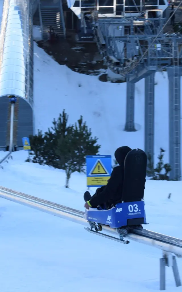 Personnes descendant une piste enneigée à bord de luges sur rail Lou Bac Mountain, à la station de ski des Angles.