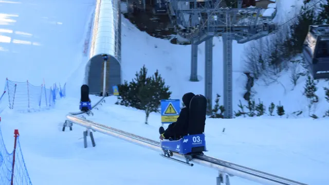 Personnes descendant une piste enneigée à bord de luges sur rail Lou Bac Mountain, à la station de ski des Angles.