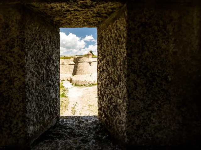 Vue des remparts de Mont-Louis à travers l’ouverture d’une meurtrière.