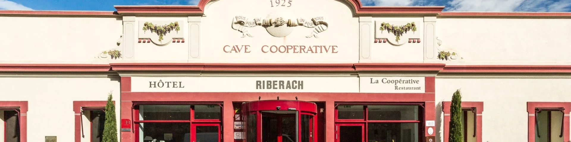 Façade de l’ancienne cave coopérative de Bélesta, avec les entrées de l’hôtel et du restaurant.