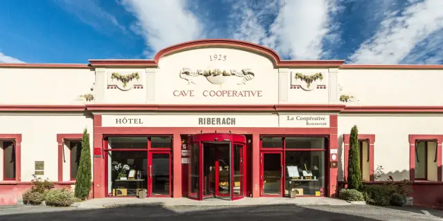 Façade de l’ancienne cave coopérative de Bélesta, avec les entrées de l’hôtel et du restaurant.