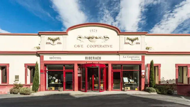 Façade de l’ancienne cave coopérative de Bélesta, avec les entrées de l’hôtel et du restaurant.