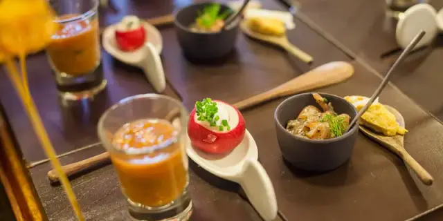 Assortiment de petites bouchées et verrines disposées sur une table.