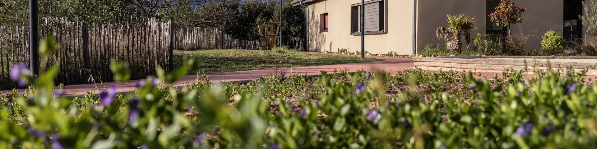Gîte Alter & Go à Marquixanes, bâtiment de plain-pied entouré de verdure avec le massif du Canigó enneigé en arrière-plan.