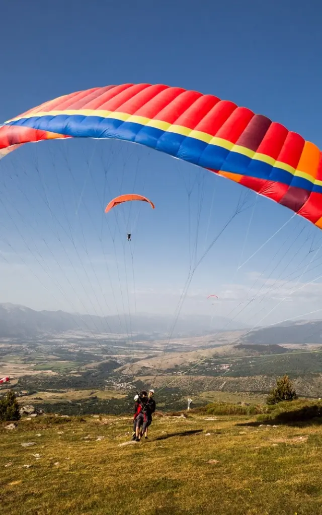 Décollage en parapente biplace à Targasonne, dominant la plaine de Cerdagne.