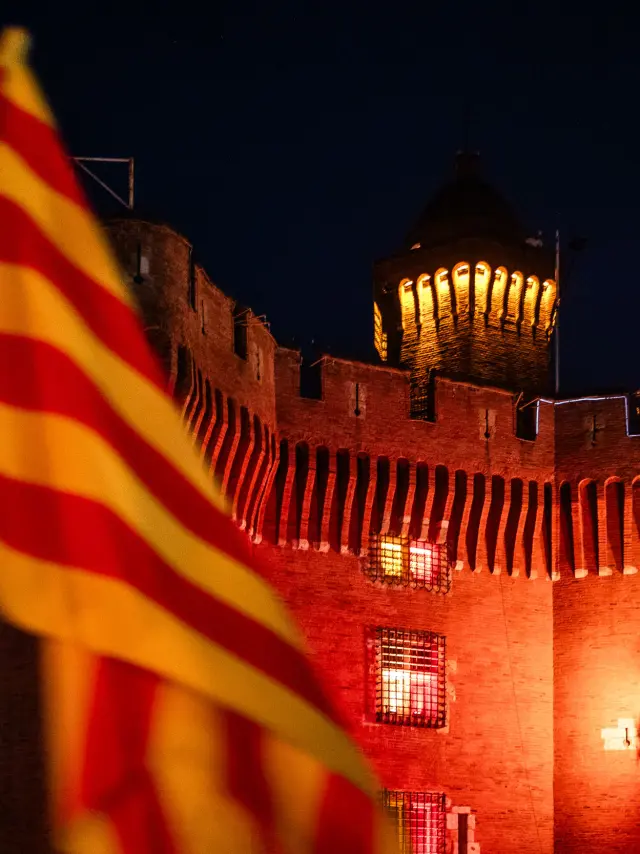 Grimpeurs escaladant le Castillet avec la flamme du Canigo dans leur dos pour embraser la derniere vasque du sommet du Castillet avec drapeau catalan sang et or depuis la Place de la Victoire a Perpignan dans le departement des Pyrenees-Orientales dans le Sud de la France le 23 juin 2026. Chaque annee la veille de la Saint Jean, la flamme eternelle des Catalans descend du Canigo pour allumer tous les villages de Catalogne avant de finir le parcours de cette tradition et ce patrimoine a Perpignan ou elle enflamme le Castillet, symbole de la ville.