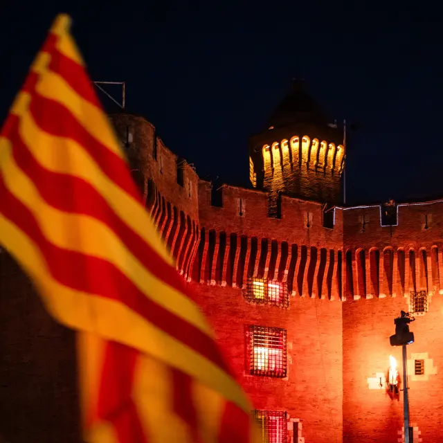 Grimpeurs escaladant le Castillet avec la flamme du Canigo dans leur dos pour embraser la derniere vasque du sommet du Castillet avec drapeau catalan sang et or depuis la Place de la Victoire a Perpignan dans le departement des Pyrenees-Orientales dans le Sud de la France le 23 juin 2026. Chaque annee la veille de la Saint Jean, la flamme eternelle des Catalans descend du Canigo pour allumer tous les villages de Catalogne avant de finir le parcours de cette tradition et ce patrimoine a Perpignan ou elle enflamme le Castillet, symbole de la ville.