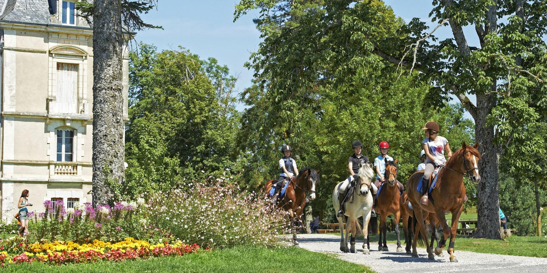 Balade à cheval d'un groupe de personnes au coeur du centre équestre de Combelles, près de Rodez