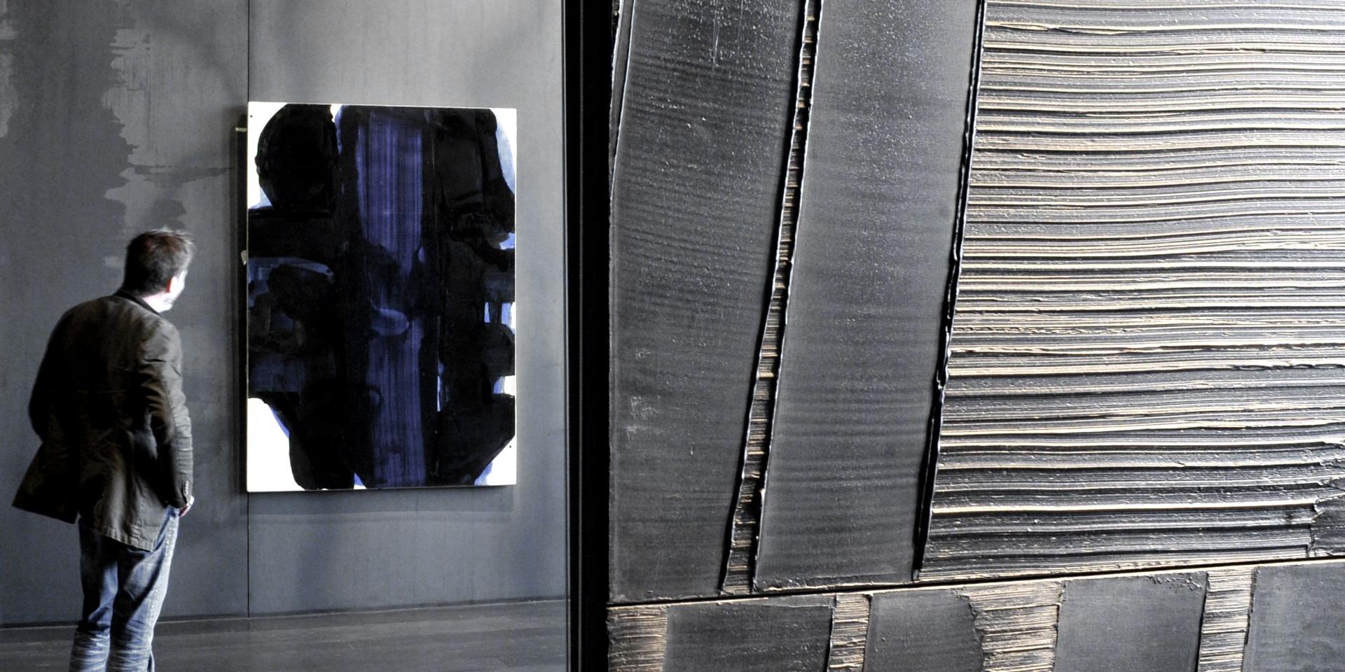 Outrenoir au premier plan, derrière une personne qui admire une autre toile avec des bleus, au musée Soulages à Rodez