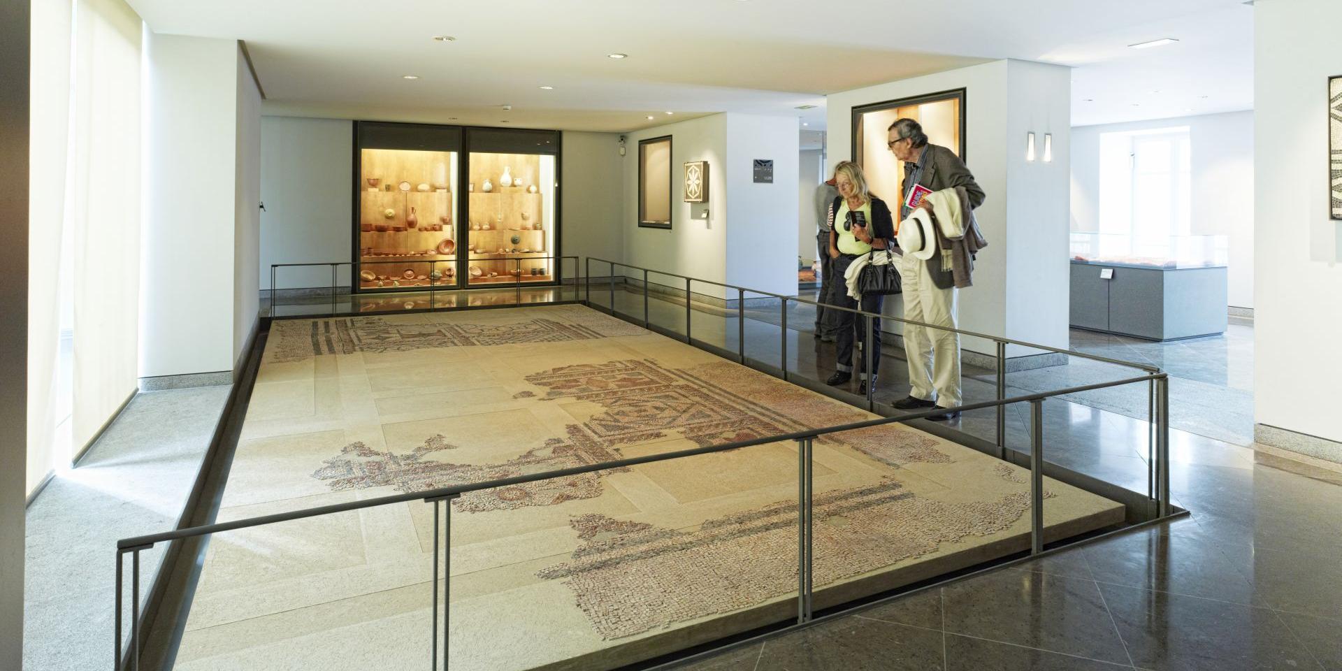 Couple de touristes admirant la mosaïque gallo-romaine exposée au sol au musée Fenaille à Rodez