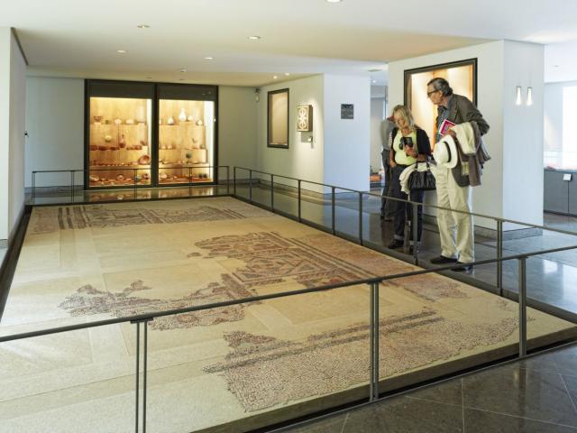 Couple de touristes admirant la mosaïque gallo-romaine exposée au sol au musée Fenaille à Rodez