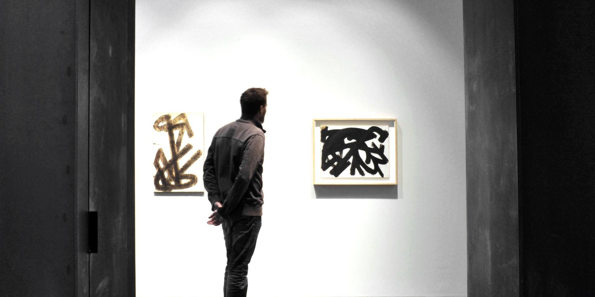 Personne admirant deux tableaux Brous de noix au musée Soulages