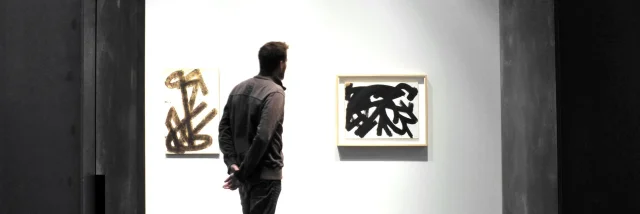 Personne admirant deux tableaux Brous de noix au musée Soulages