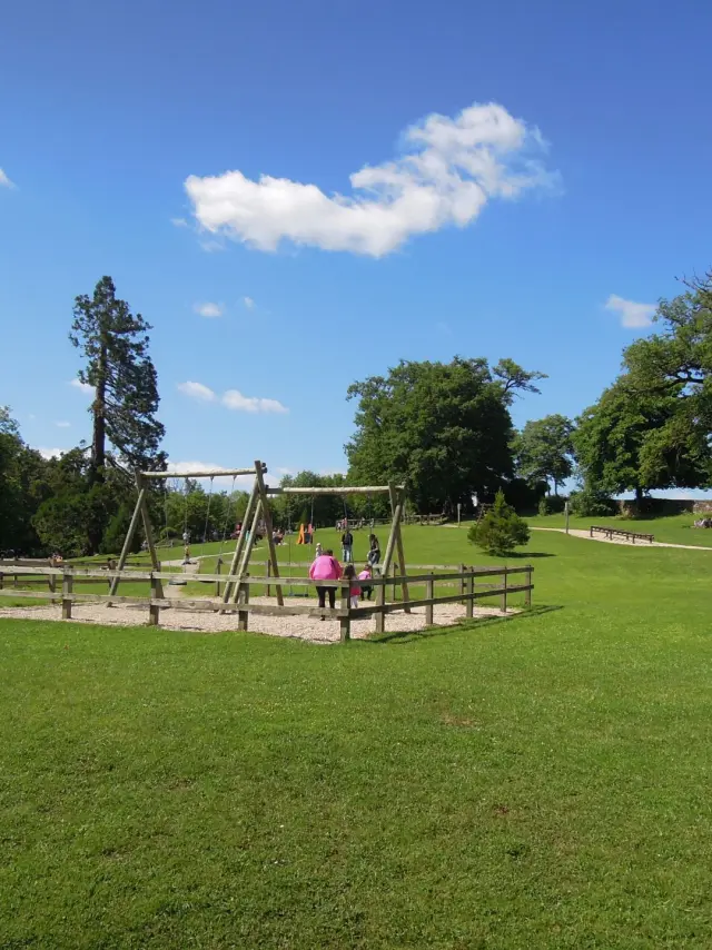 Famille s'amusant aux balançoires au milieu du Parc de Vabre à Rodez