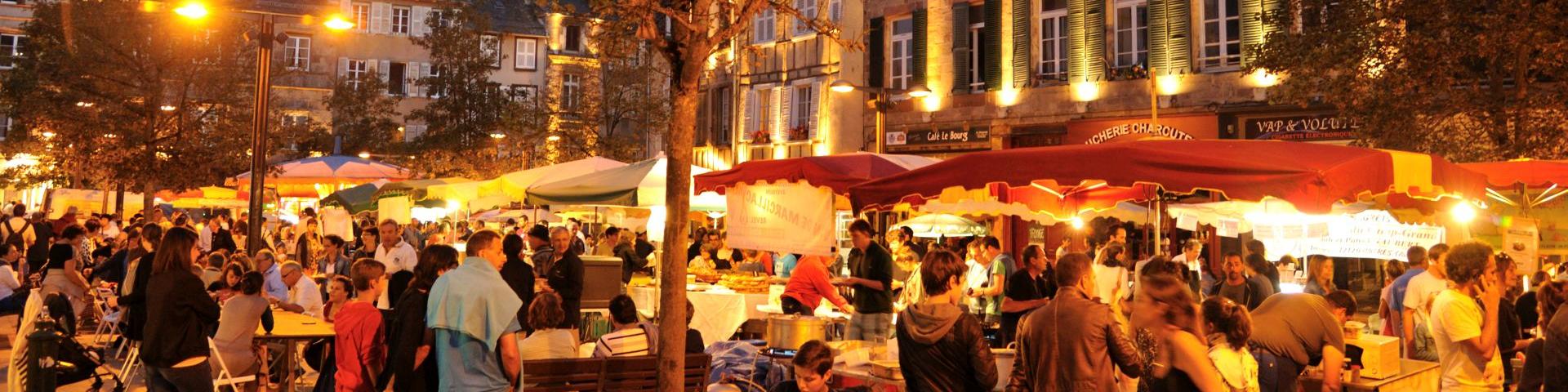 Foule de personnes présentes au marché gourmand nocturne de l'été, sur une place historique de Rodez