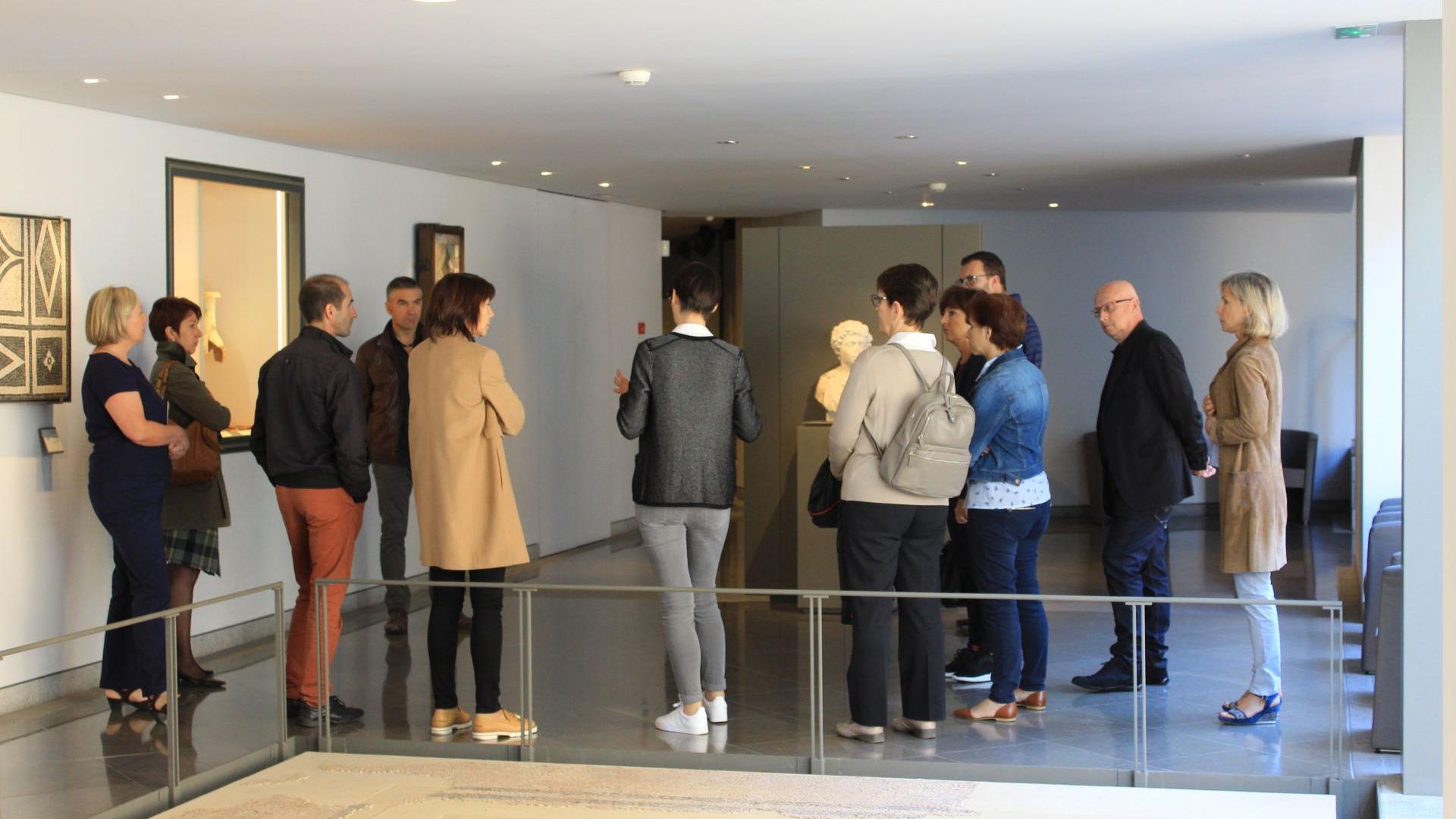 Groupe de visiteurs autour de la guide, au musée Fenaille