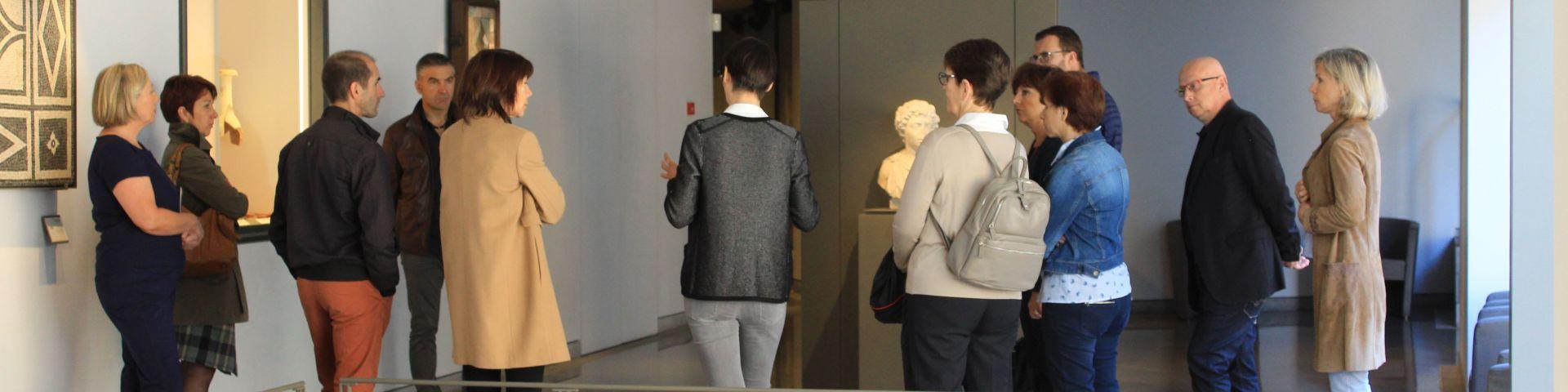 Groupe de visiteurs autour de la guide, au musée Fenaille
