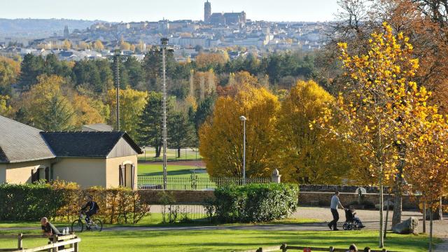 Enfants jouant aux jeux de bois sous les yeux de leurs parents, au parc de Vabre, avec vue sur la cathédrale au loin