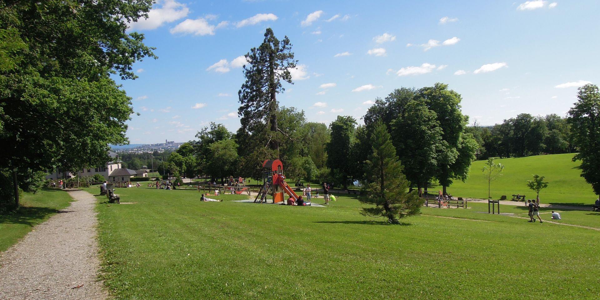 Personnes se délassant au soleil sur la pelouse tout surveillant leurs enfants en train de jouer aux jeux en bois du Domaine de Vabre