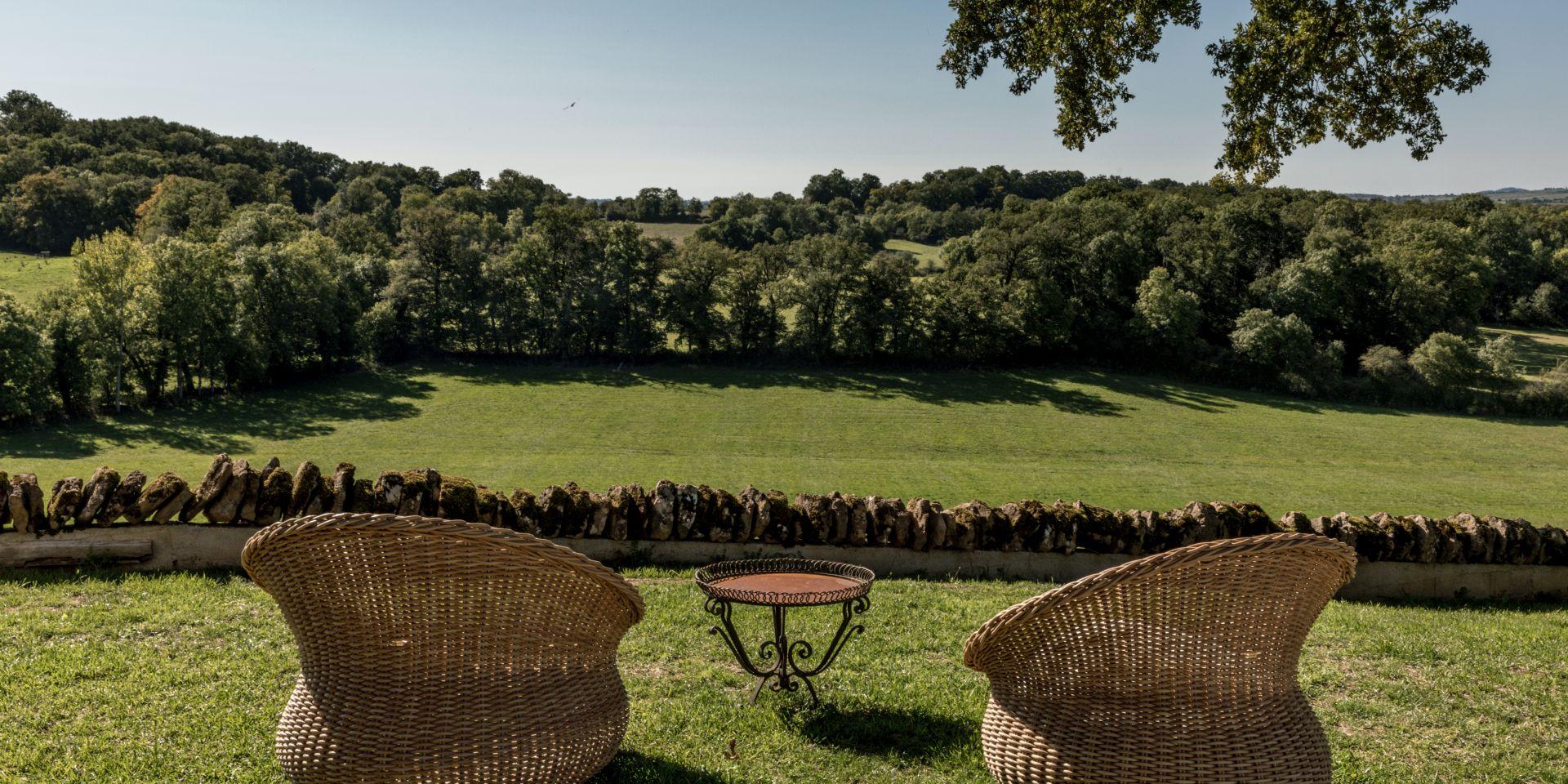 Deux fauteuils de type Loveuses face à la nature et un mur de pierres au Château de Labro