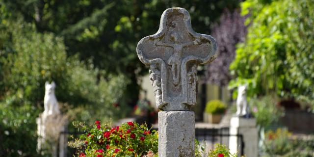 Croix sculptée en pierre représentant le Christ à Olemps