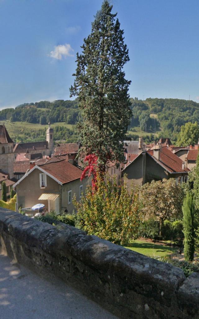 Vue sur les toits de Figeac depuis une place en hauteur avec un muret