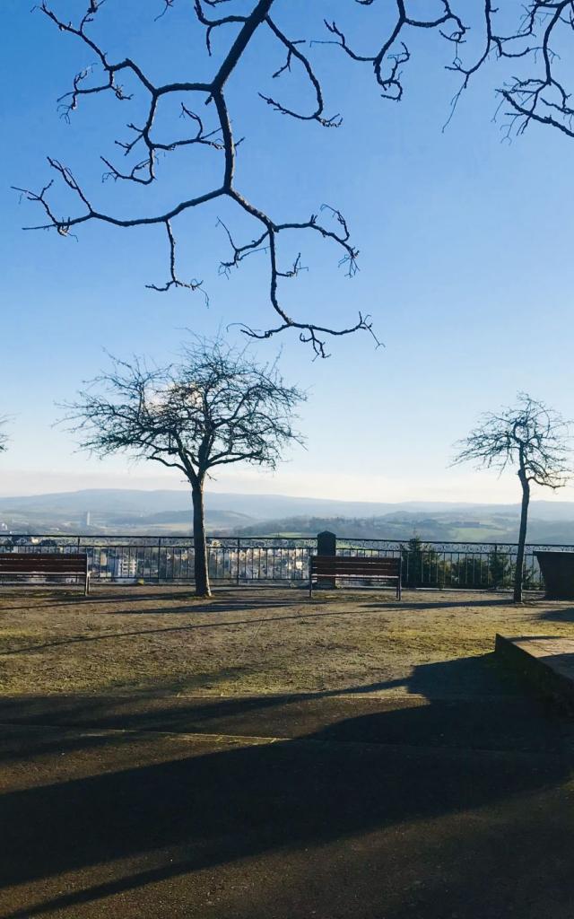 Square Bonnefé avec le buste en bronze du docteur Bonnefé devant son autel en pierre, avec son esplanade sableuse et ses bancs installés entre des arbres ace à la vue dégagée sur les alentours de Rodez