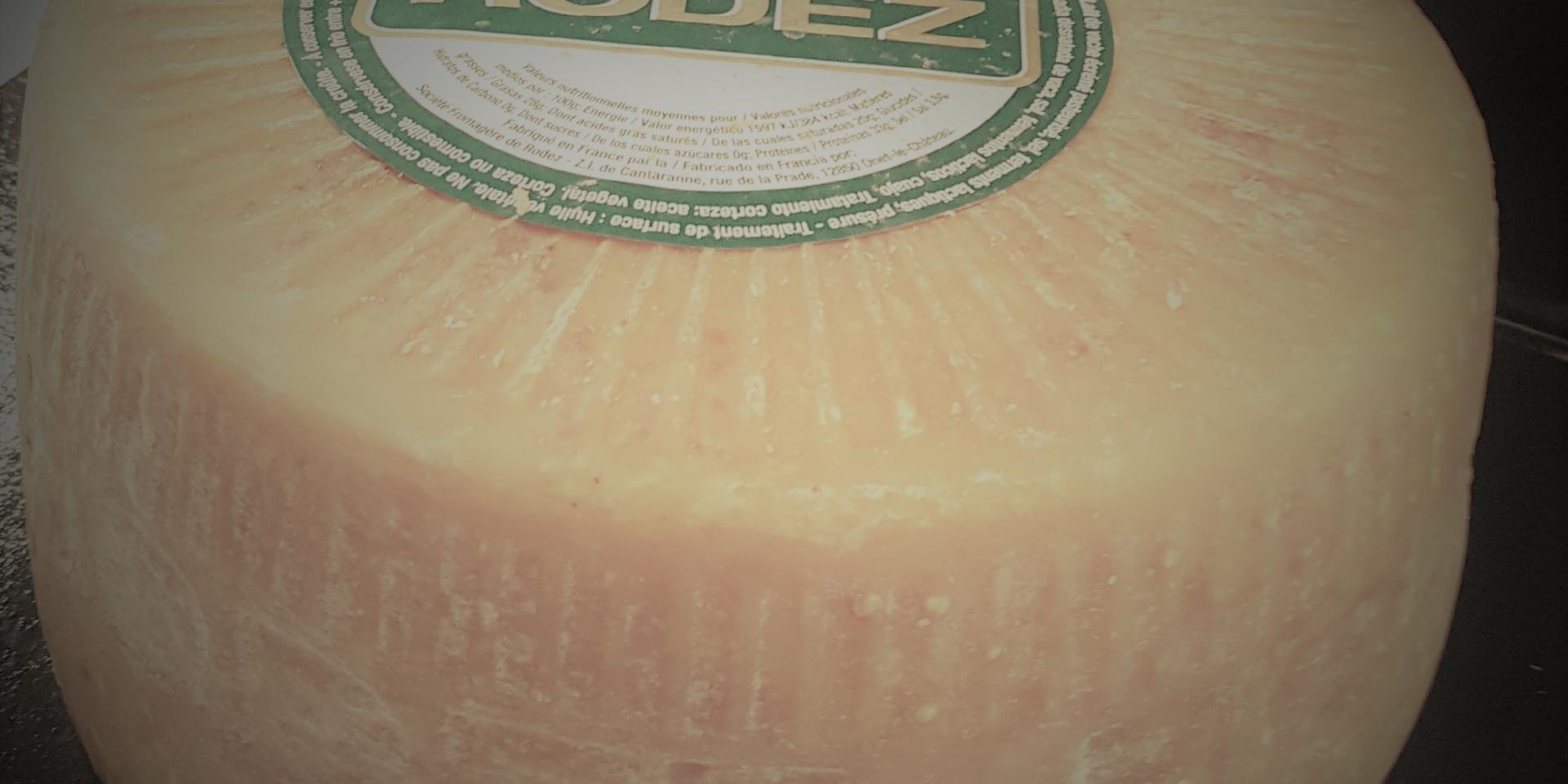Meule ronde entière de fromage Le Rodez avec son étiquette au sommet blanche et verte