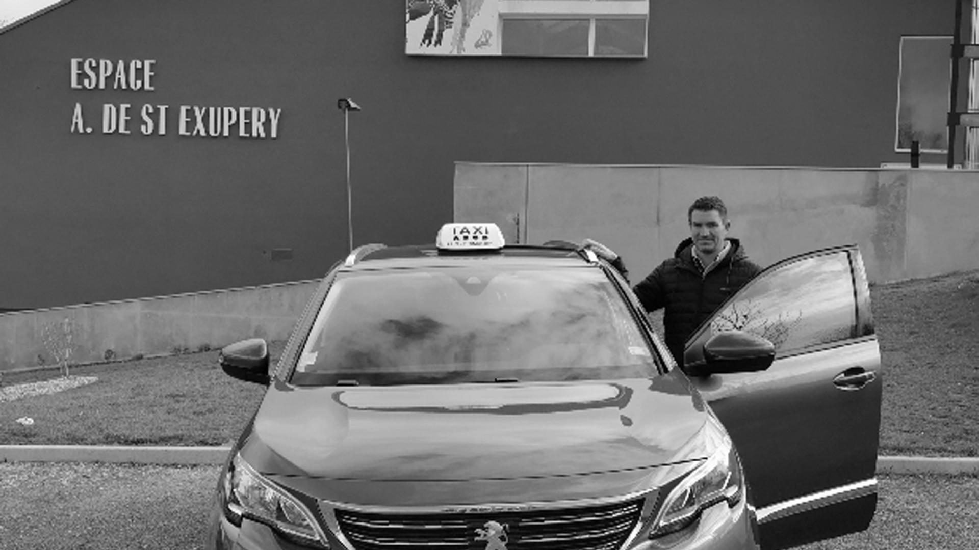 Personne à côté de son taxi devant l'espace Saint Exupéry