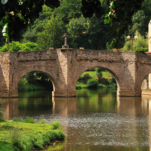 Pont en pierre avec sa croix au-dessus de la rivière Aveyron au Monastère