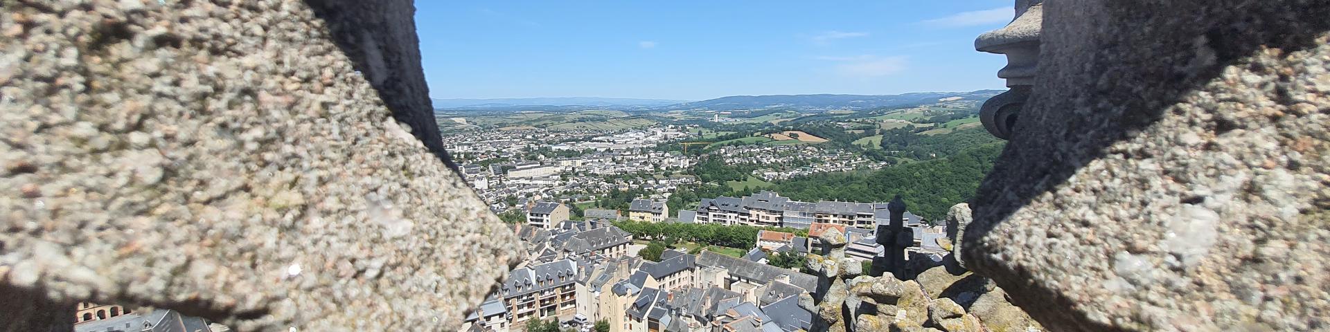 Vue sur le centre historique de Rodez à travers une fenêtre sculptée en pierre du clocher de la cathédrale