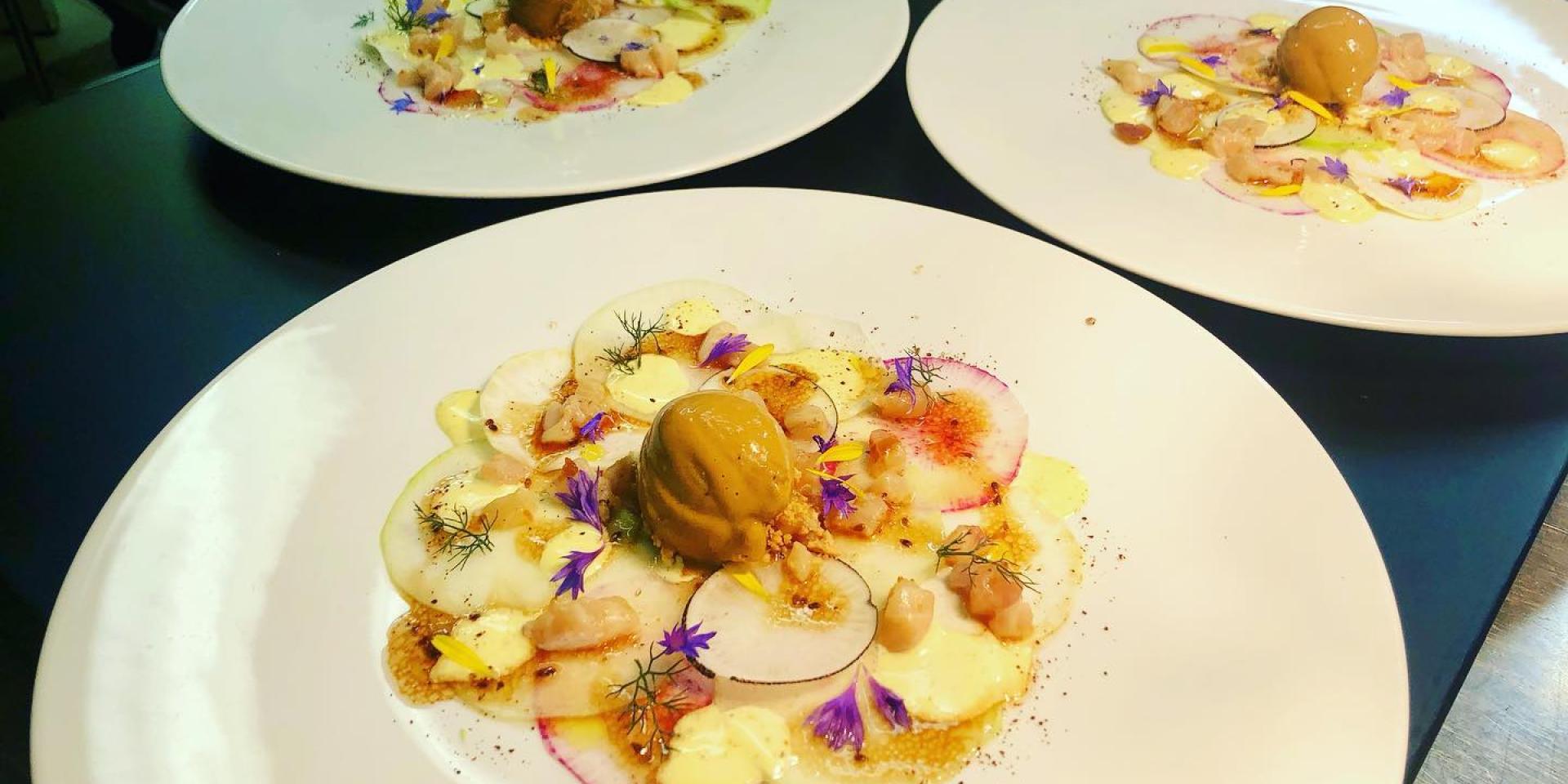 Plat gastronomique joliment décoré avec des fleurs, concocté par le restaurant Opéra