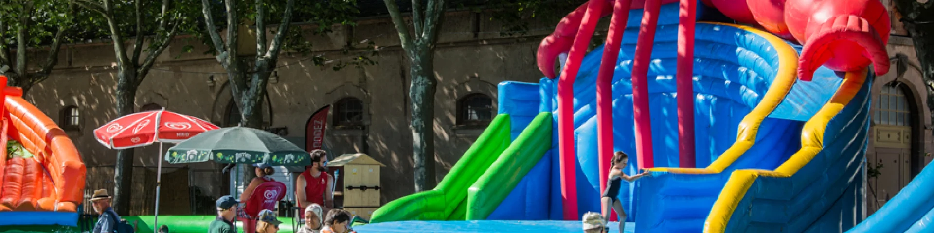 Parents devant des jeux gonflables et des jeux d'eau où s'amusent leurs enfants