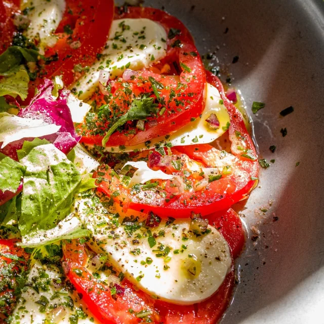 Assiette de salade végétarienne avec des feuilles de salade coupées, des tomates, des herbes, de l'huile d'olive