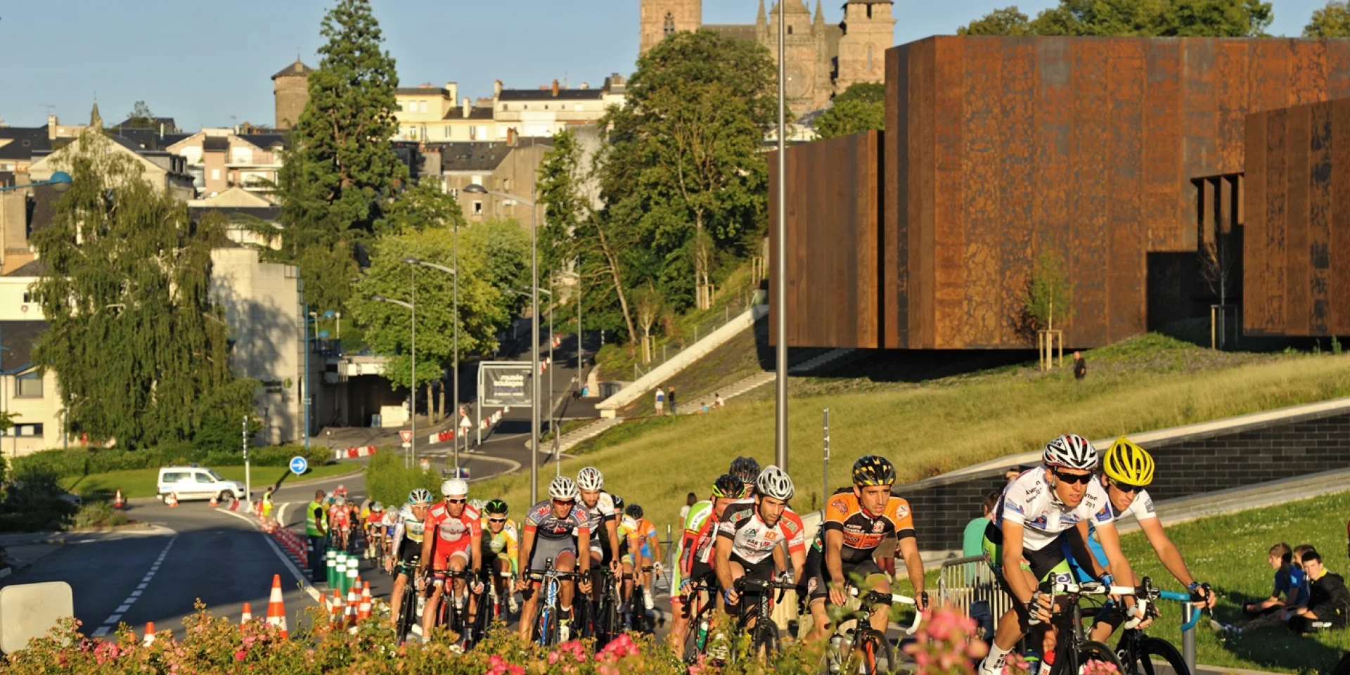 Course cycliste se déroulant sur la route à côté du musée Soulages, dos à la cathédrale de Rodez