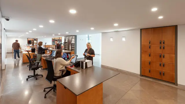 Comptoir de l'office de tourisme et musée Fenaille avec des agents qui renseignent des clients