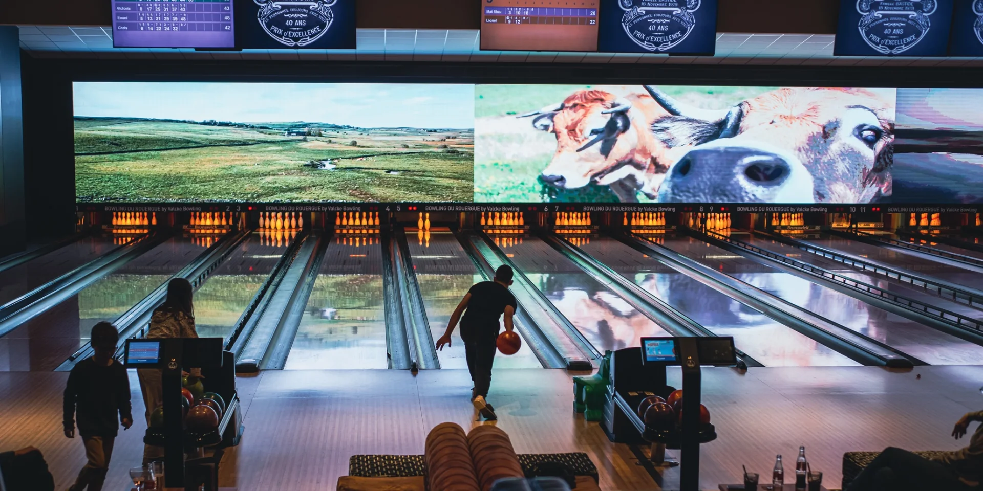 Personne lançant une boule de bowling sur la piste, vers les quilles