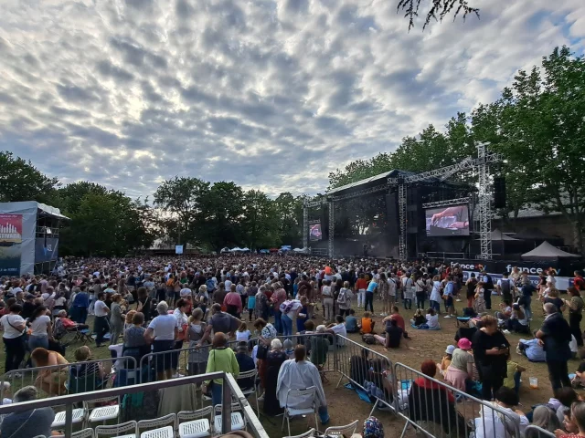 Foule devant un concert plein air avec écran géant