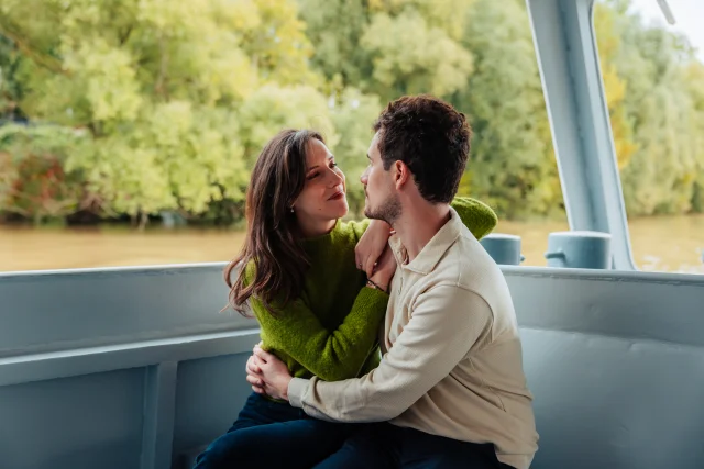 Couple sur un bateau lors d'une croisière qui se regarde et s'enlace