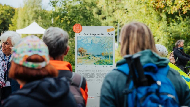 Groupe de randonneurs devant un panneau du Chemin des Impressionnistes au Port-Marly