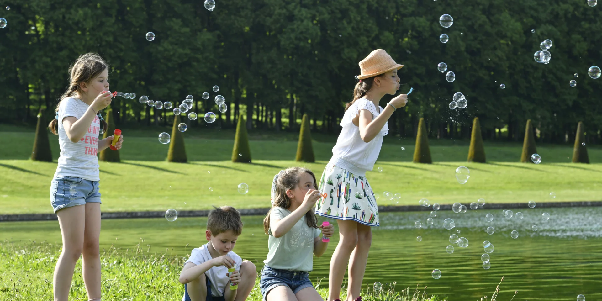 Enfants qui s'amusent à faire des bulles dans le Domaine de Marly.