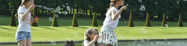 Enfants qui s'amusent à faire des bulles dans le Domaine de Marly.