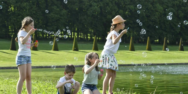 Enfants qui s'amusent à faire des bulles dans le Domaine de Marly.