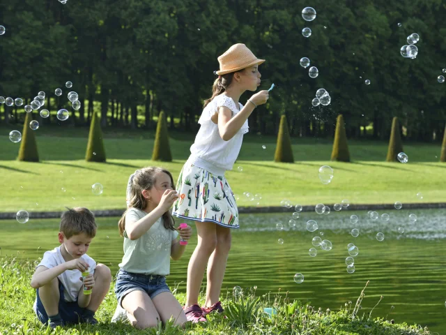 Enfants qui s'amusent à faire des bulles dans le Domaine de Marly.