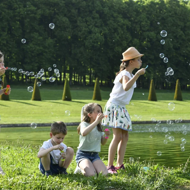 Enfants qui s'amusent à faire des bulles dans le Domaine de Marly.