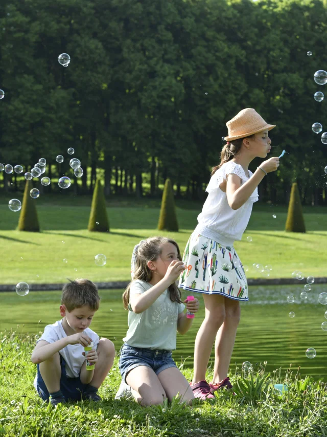 Enfants qui s'amusent à faire des bulles dans le Domaine de Marly.