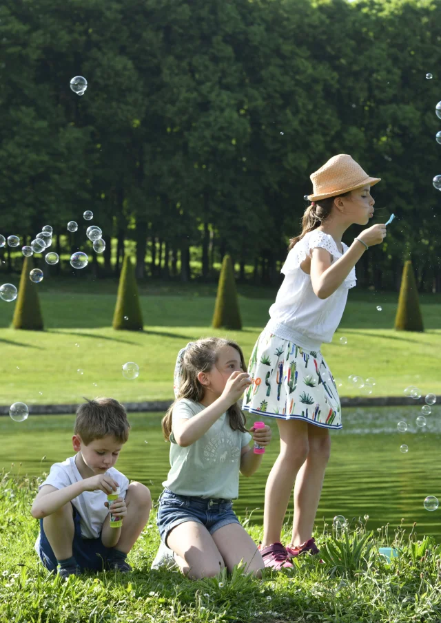 Enfants qui s'amusent à faire des bulles dans le Domaine de Marly.