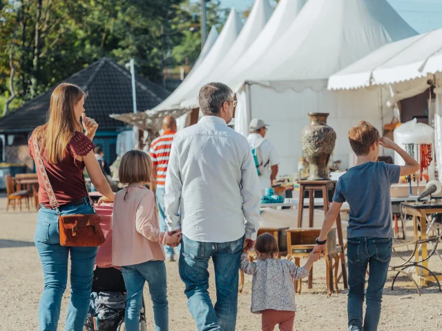 Famille avec les deux parents et les trois enfants marchant de dos à la foire de Chatou